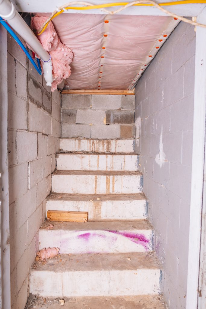 Concrete stairwell leading to basement at 11 Sherman Street, Dennison, Ohio with exposed block walls