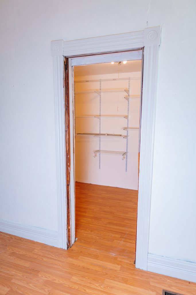 Closet entry from first-floor bedroom at 11 Sherman Street, Dennison, Ohio showing walk-in closet with shelving, remodeled in 2019