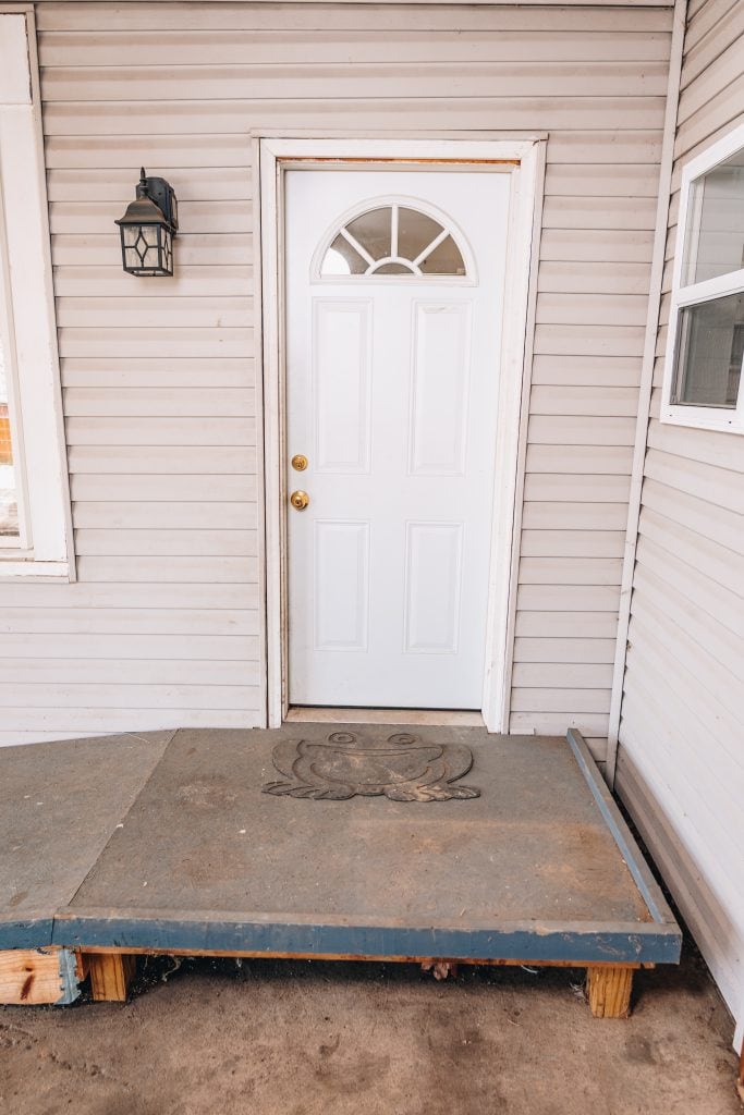Front door of home at 11 Sherman Street, Dennison, Ohio featuring white door with decorative glass and entry ramp.