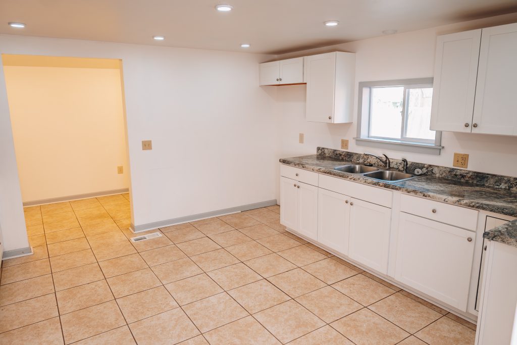 Kitchen sink area at 11 Sherman Street, Dennison, Ohio with granite countertops and white cabinets.