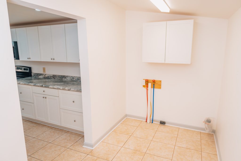 Laundry room at 11 Sherman Street, Dennison, Ohio with plumbing hookups and wall cabinet.